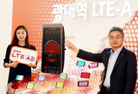 Lee jong-bong, Executive Vice President and Head of Network Division, and Kim Yuna, a model of the new commercial, posing in front of the speedometer for 225Mbps LTE-Advanced.