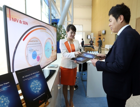 Employees of SK Telecom are introducing a white paper on 5G to visitors at the company’s booth during 5G Global Summit, an international 5G conference, held in Busan.