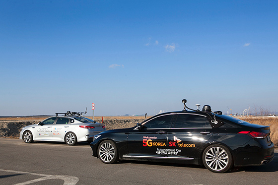 Two 5G self-driving cars are driving side by side on the road 