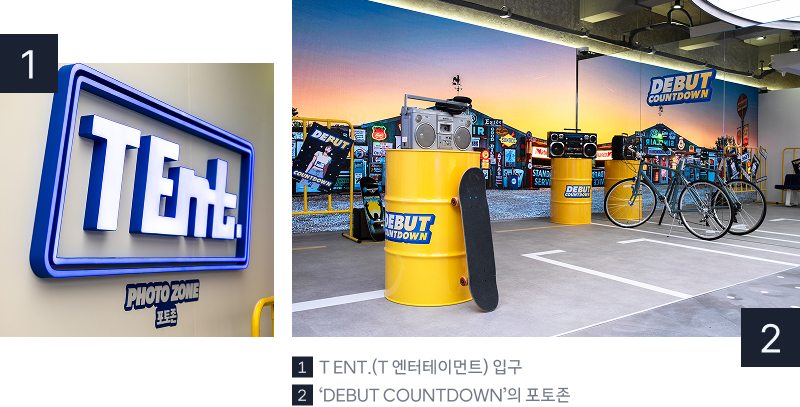 T팩토리 성수 1층 ‘T ENT.’ 공간. 첫 번째 사진은 포토존 입구 벽면에 설치된 파란색 T ENT. 로고 사인과 PHOTO ZONE 표시. 두 번째 사진은 ‘DEBUT COUNTDOWN’ 포토존 전경으로, 노란 드럼통, 스피커, 자전거, 스케이트보드 소품이 배치된 거리 콘셉트 공간. 이미지 내 텍스트 1. T ENT.(T 엔터테인먼트) 입구, 2.‘DEBUT COUNTDOWN’의 포토존