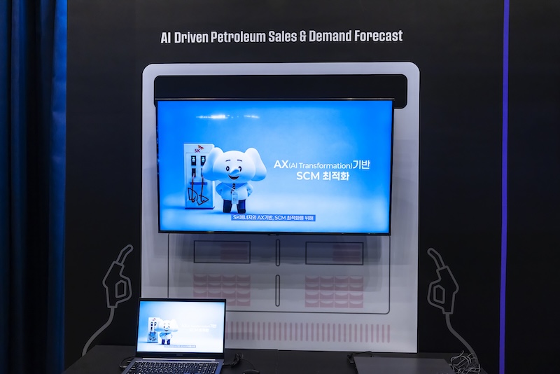 ‘A.X 기반 SCM 최적화’ 화면에 주유소 코끼리 캐릭터와 지역별 수요 예측 데이터가 함께 표시되어 있다. AI가 석유 수급을 실시간으로 예측·최적화하는 장면이다.