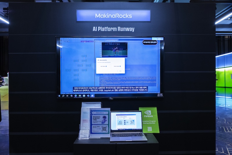 MakinaRocks 부스의 ‘AI Platform Runway’ 전시 화면. 노트북과 대형 모니터를 통해 AI 플랫폼 데모 영상이 재생되고 있다.