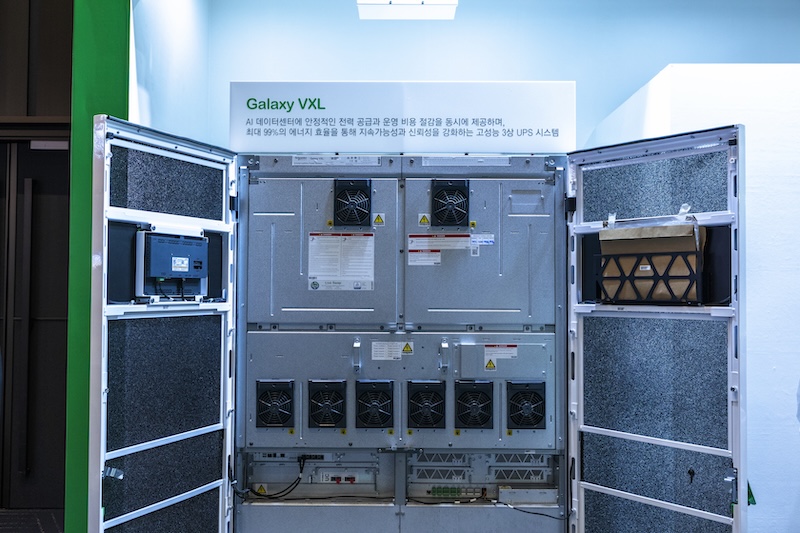 ‘Galaxy VXL’ UPS 시스템 내부가 공개된 전시물. 다수의 냉각 팬과 모듈 구조가 드러나 있으며, 벽면에는 에너지 효율 및 안정성 설명이 쓰여 있다.
