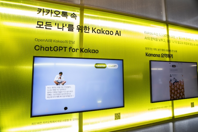 ‘ChatGPT for Kakao’ 전시 화면. 노란 배경 위 모니터에 카카오톡 대화창 속 ChatGPT 시연 장면이 보인다.
