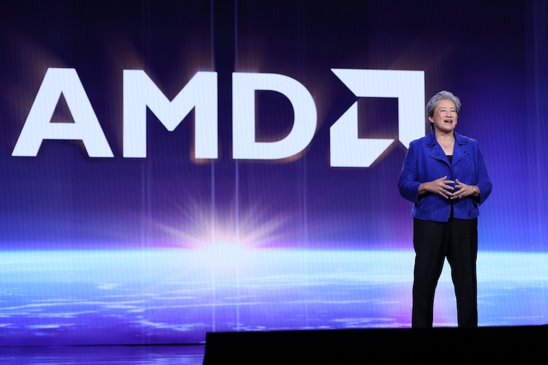 AMD CEO 리사 수가 대형 ‘AMD’ 로고를 배경으로 무대에 서서 키노트를 진행하고 있는 장면.