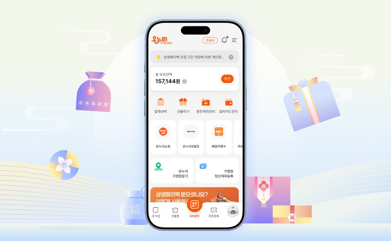 중앙에 스마트폰 화면이 크게 배치되어 있으며, 화면에는 온누리상품권 잔액과 선물하기, 충전, 사용 내역 등의 메뉴가 아이콘 형태로 표시되어 있다. 스마트폰 주변에는 선물 상자와 명절 장식 일러스트가 함께 배치되어 모바일로 간편하게 선물을 관리하는 상황을 표현하고 있다.