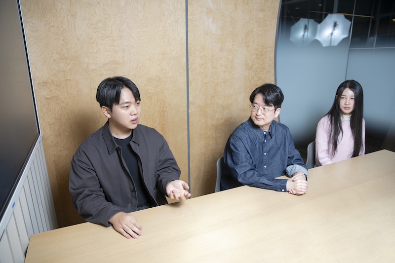 회의 테이블에 함께 앉아 있는 양현호 님, 천성준 님, 이유진 님. 양현호 님이 말하는 동안 천성준 님과 이유진 님이 경청하고 있다.