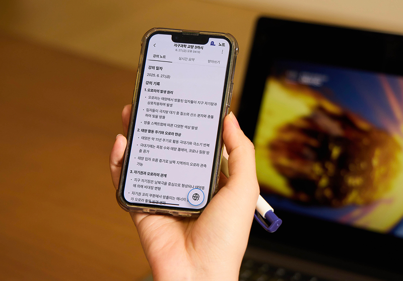 휴대폰을 들고 있는 모습. 휴대폰에는 에이닷 노트가 켜져 있고, 지구과학 교양 강의 기록 요약이 나와 있다.