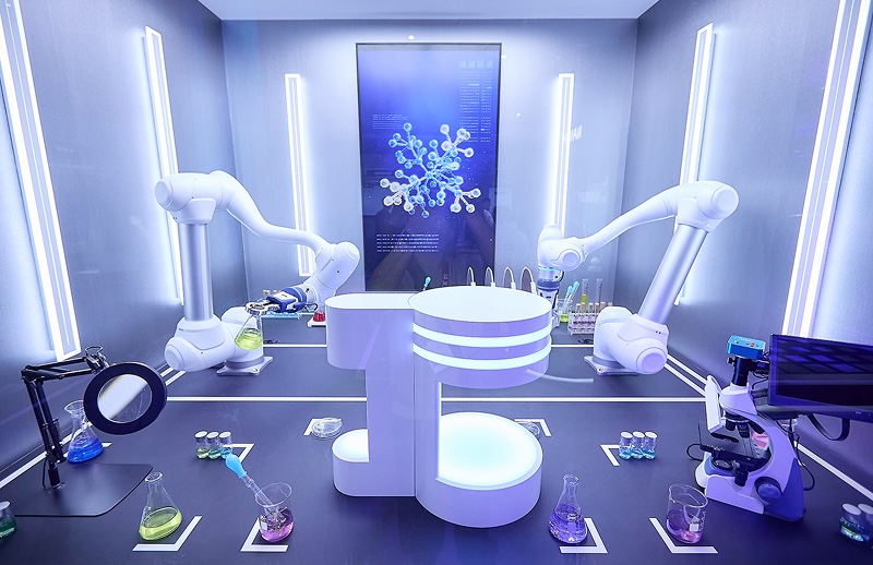 MWC26 SKT의 AI 서비스(Service) 존 전시 공간으로 로봇 팔과 실험 장비, 현미경 등이 배치된 AI 연구실 형태의 체험 전시 부스 모습