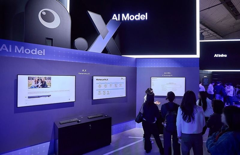 MWC26 SK텔레콤 부스에서 AI Model 존에 전시된 A.X K1 모델을 관람객들이 시연 화면을 통해 체험하고 있는 모습