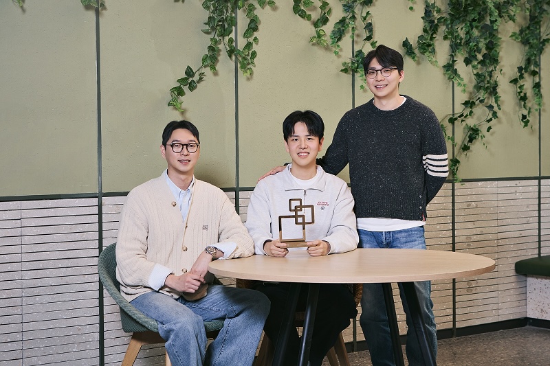 좌측부터 GPUaaS 상품개발팀 양상훈, 이재협, 최지만 님이 실내 테이블 앞에서 함께 포즈를 취하고 있는 모습으로, 가운데 인물은 트로피를 들고 있고 양옆 인물이 함께 서 있거나 앉아 기념 촬영을 하고 있는 장면