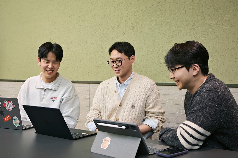 회의실 테이블에 앉은 이재협, 양상훈, 최지만 님이 각자 노트북과 태블릿을 두고 웃으며 대화하는 모습