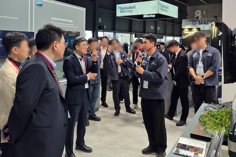 MWC26 4YFN SKT SKTCH 전시관에서 인베랩(InvaLab) 신원협 대표가 생태복원 기술을 설명하고 있다. 테이블 위에 시드볼과 생태복원 모형이 놓여 있다.