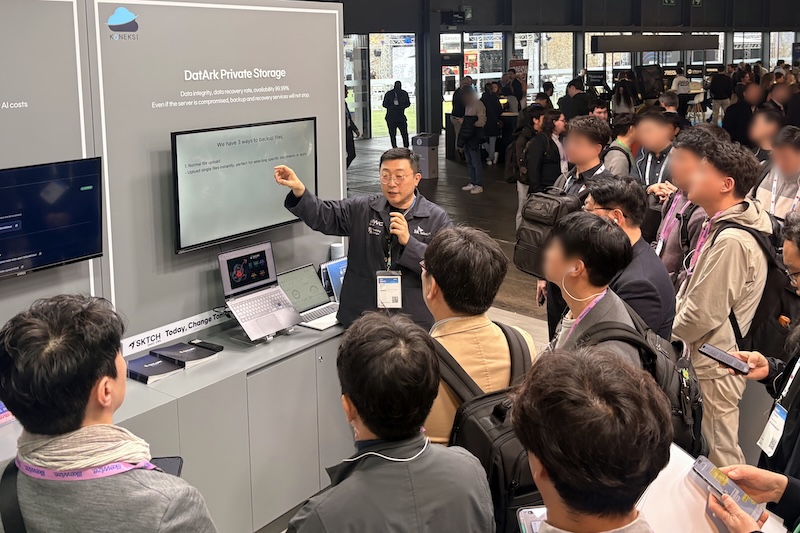 MWC26 4YFN SKT SKTCH 전시관에서 코넥시(KONEKSI) 최영일 대표가 DatArk Private Storage 솔루션을 시연하며 관람객들에게 설명하고 있다.